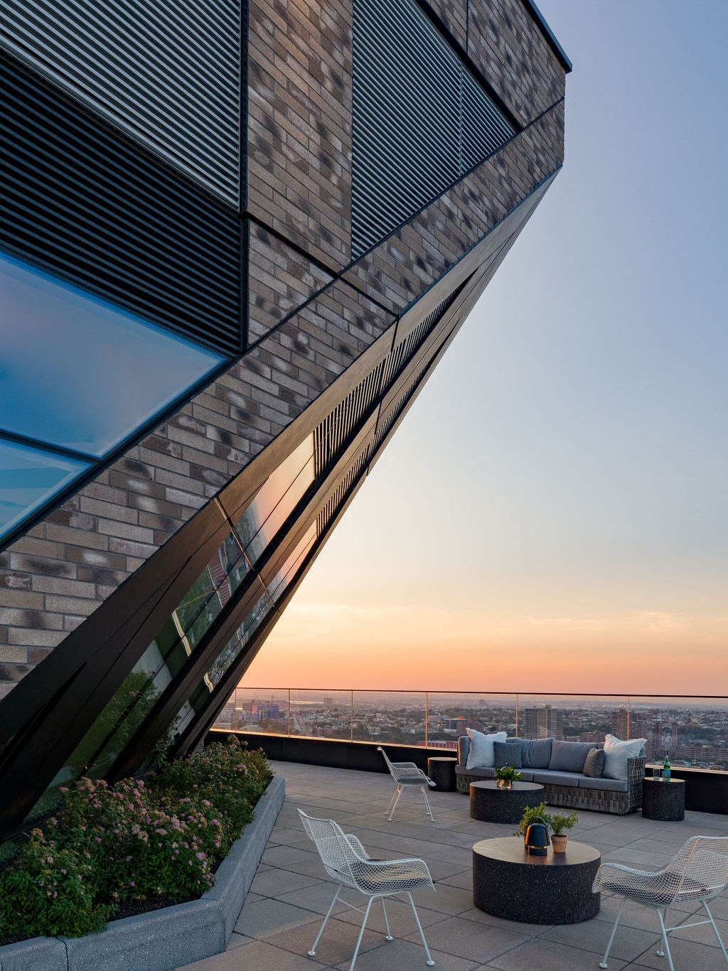 the rooftop terrace of the building has views of the city and the sunset