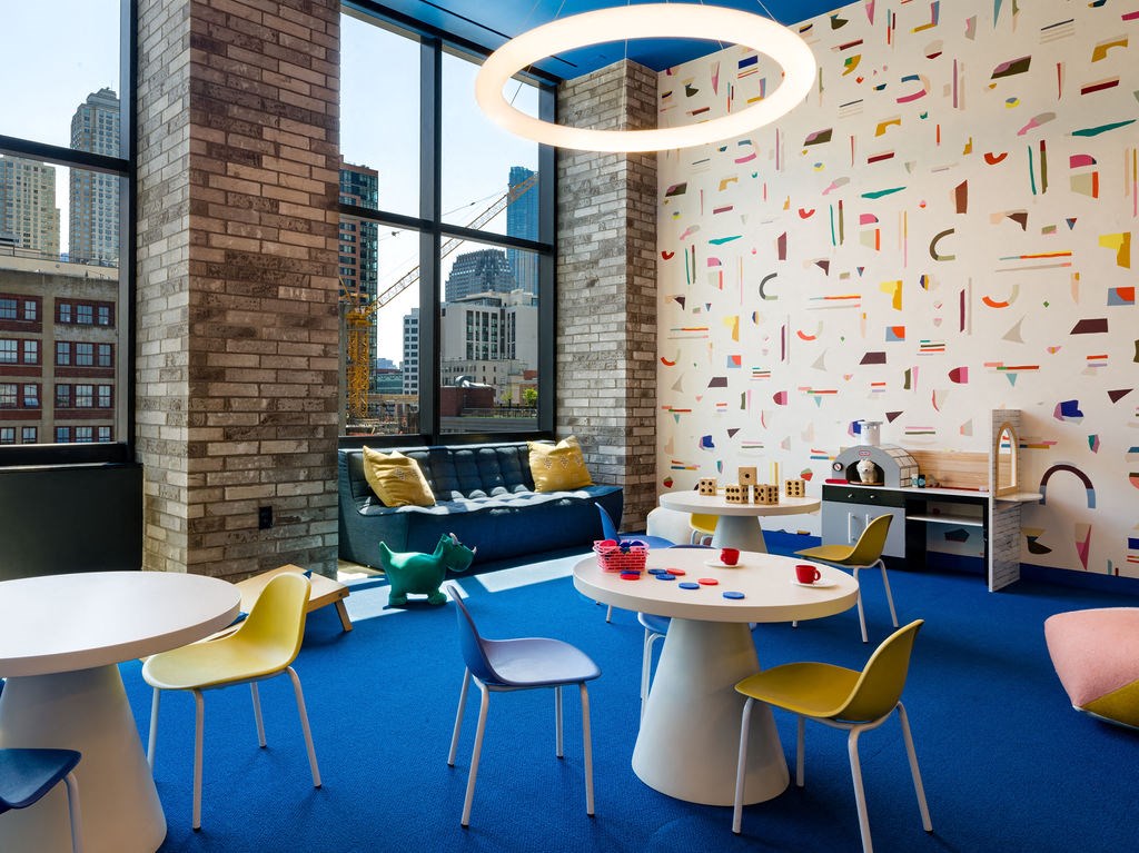 a room with a table and chairs and a large window