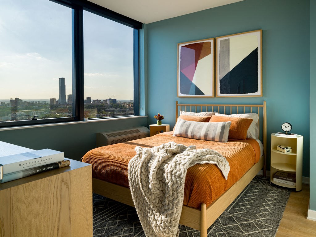 a bedroom with a bed and a large window