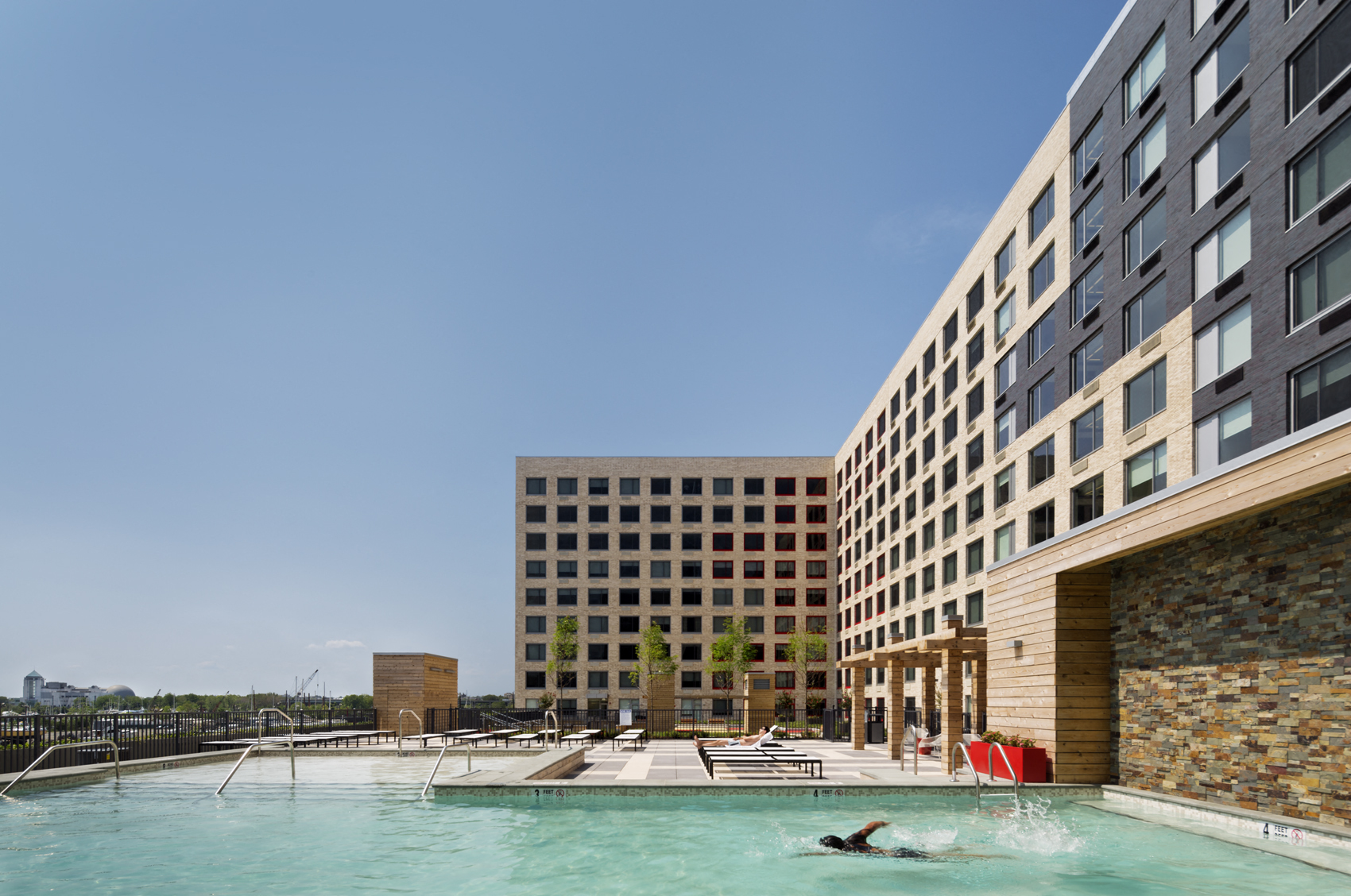 a person swimming in a pool in front of a tall building