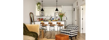 A kitchen with a bar and a checkered chair.