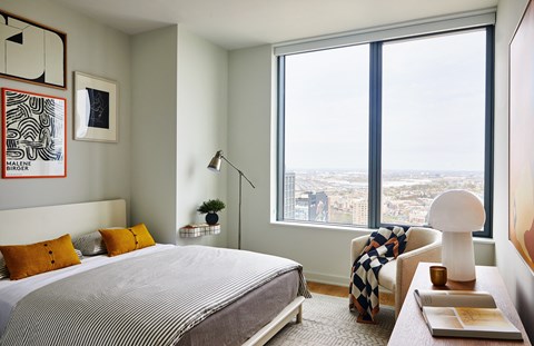 a bedroom with a bed and a large window