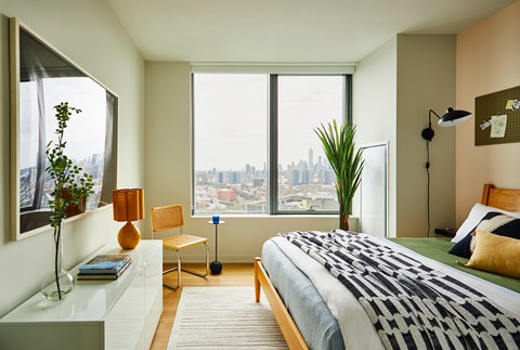 a bedroom with a bed and a view of the city