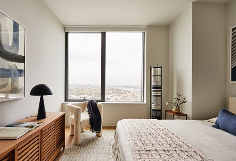 a bedroom with a bed and a large window