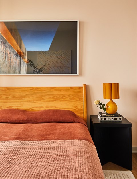 a bedroom with a bed and a painting on the wall