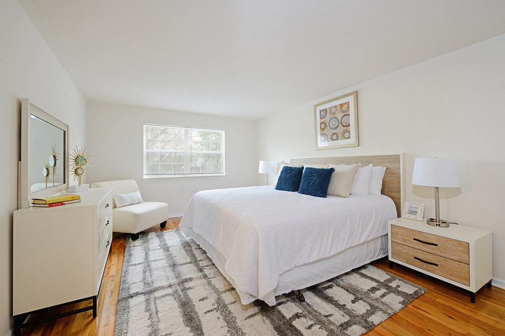 a bedroom with a white bed and a white dresser