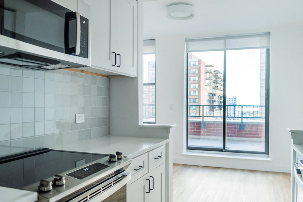 a kitchen with a window and a stove and a microwave