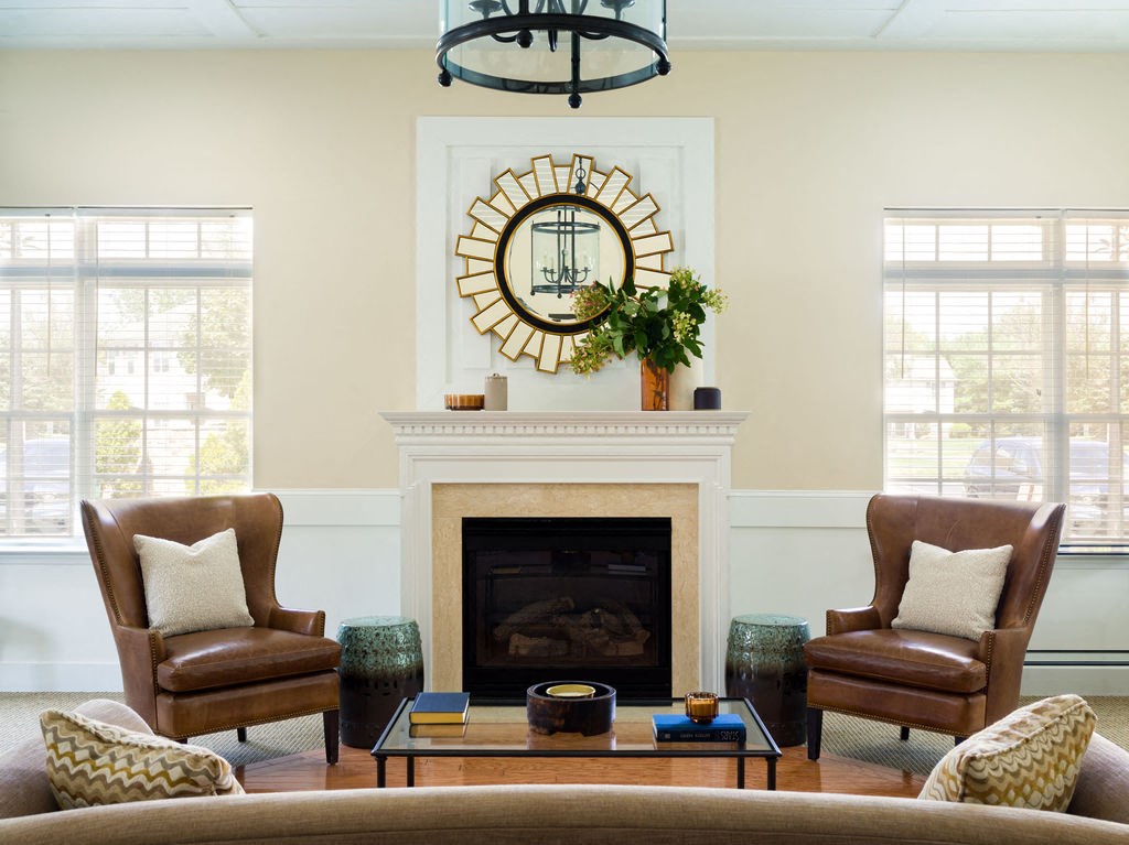 a living room with a fireplace and chairs