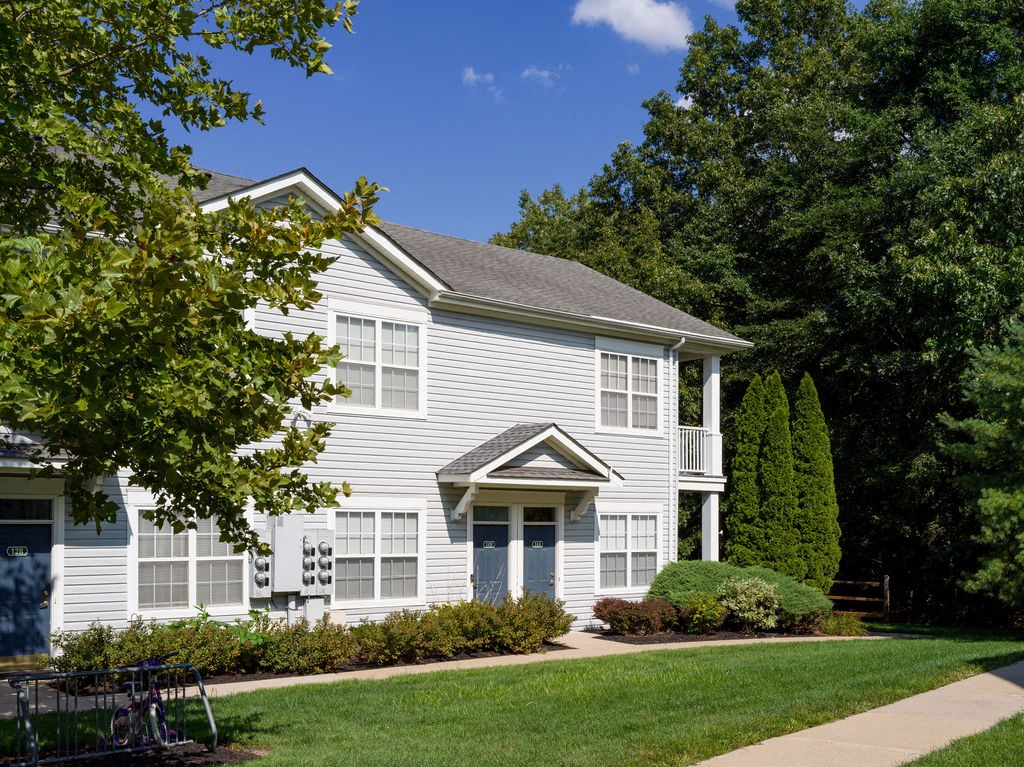 a white house with a sidewalk in front of it