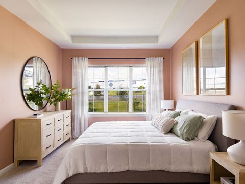 a bedroom with pink walls and a white bed