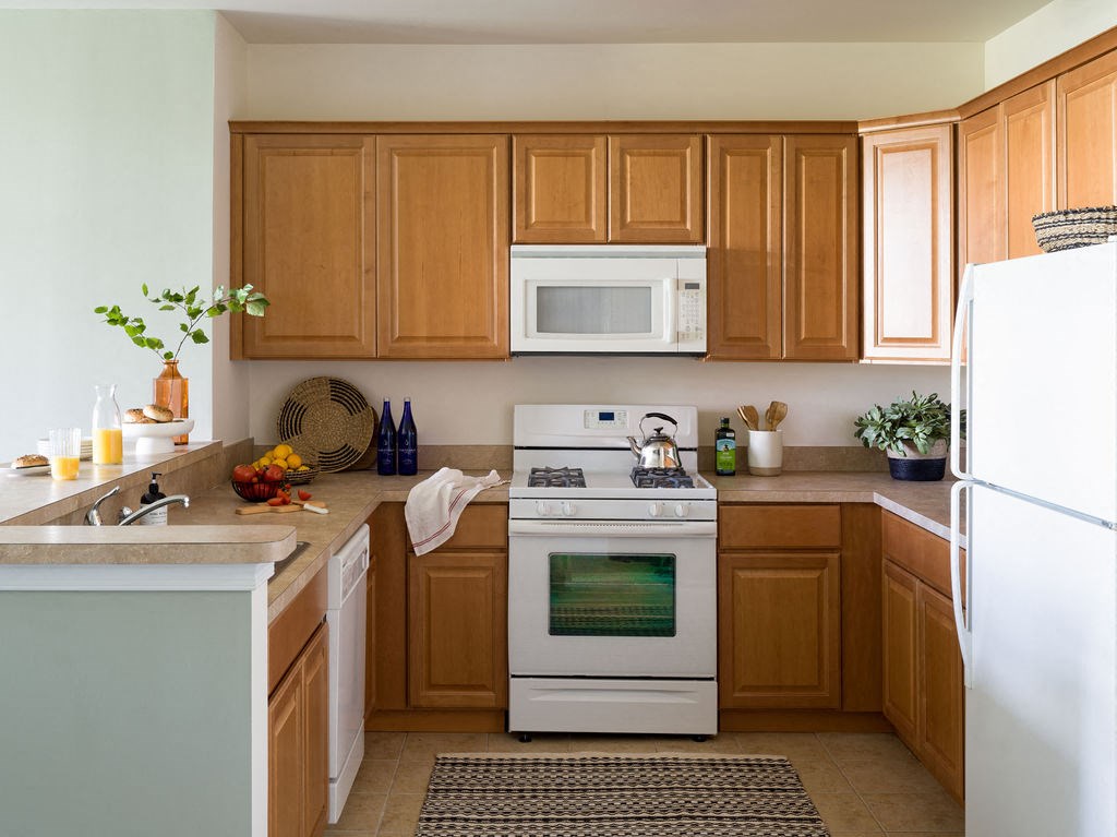 a kitchen with white appliances and wooden cabinets