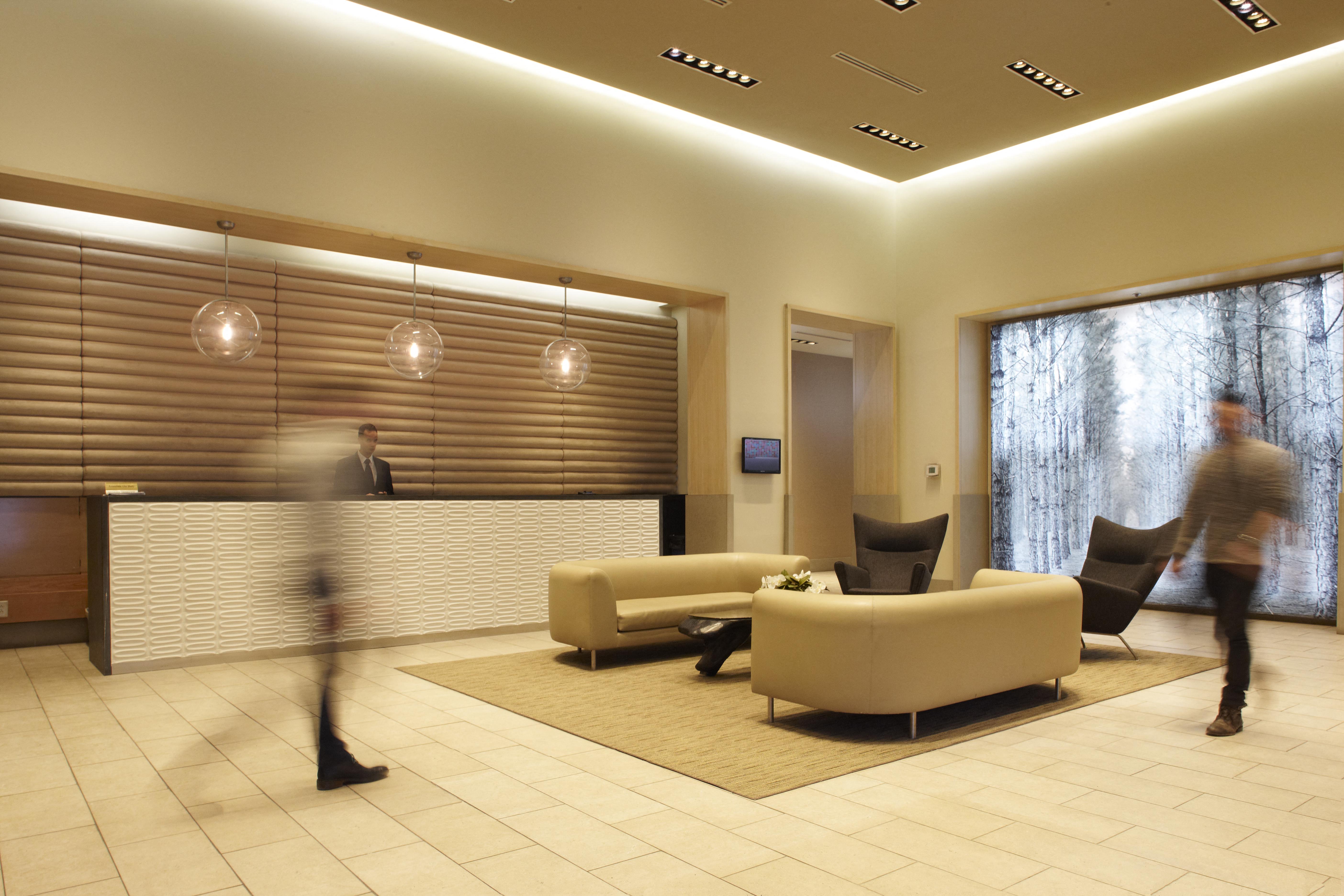 a rendering of a lobby with couches and a reception desk