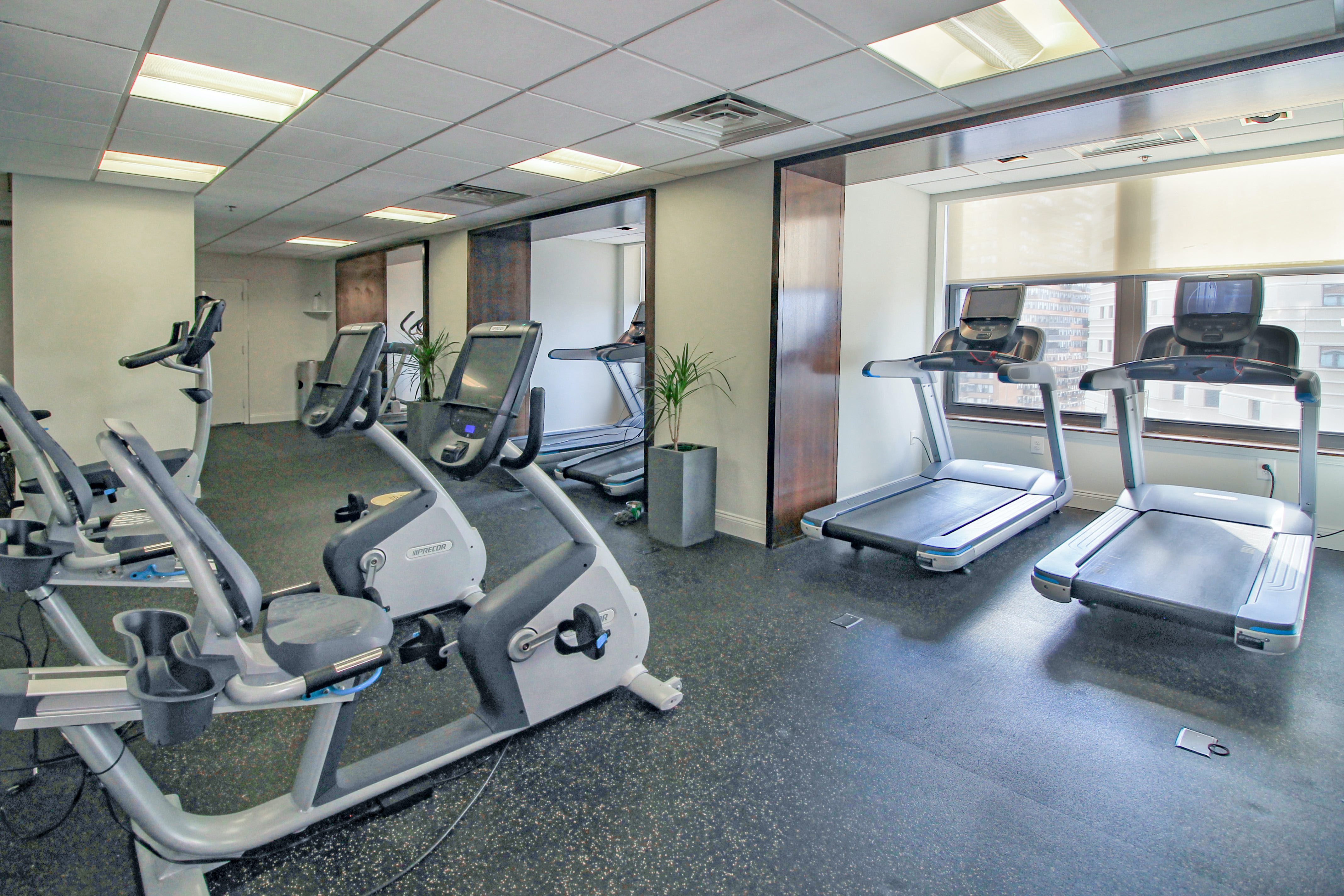 a gym with cardio equipment and weights in a building
