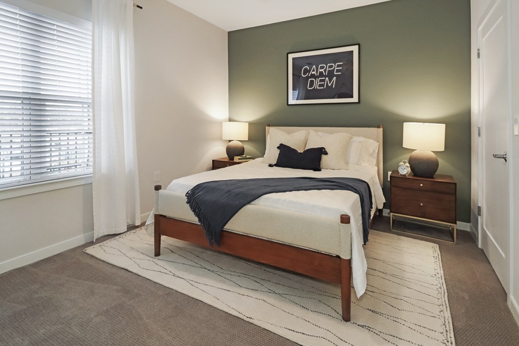 a bedroom with a bed and two nightstands and a window