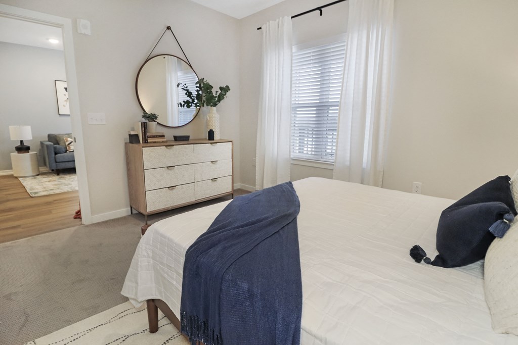 a bedroom with a bed and a dresser with a mirror