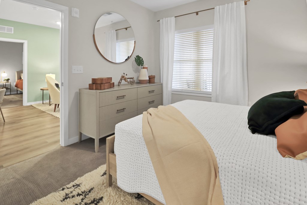 a bedroom with a bed and a dresser with a mirror