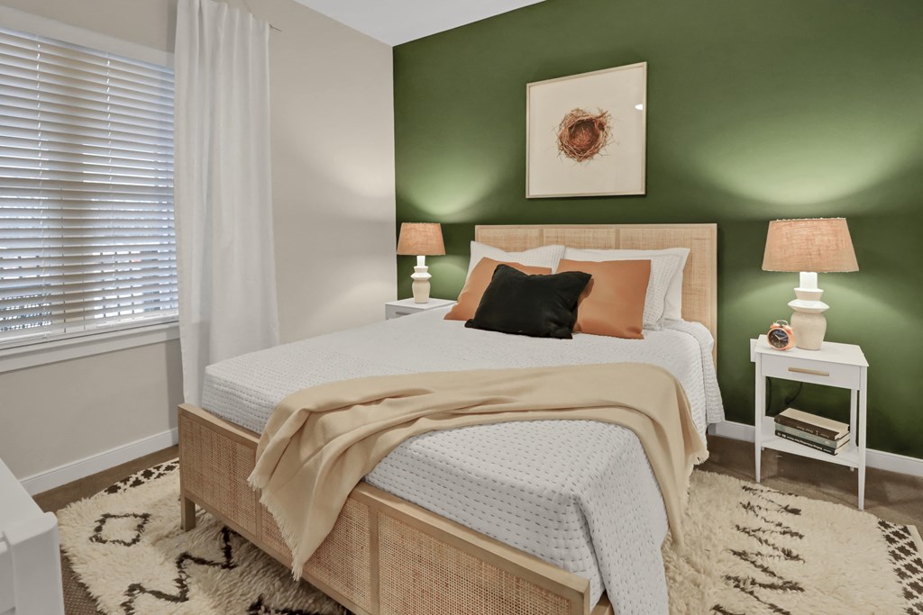 a bedroom with a bed and a green wall and a window