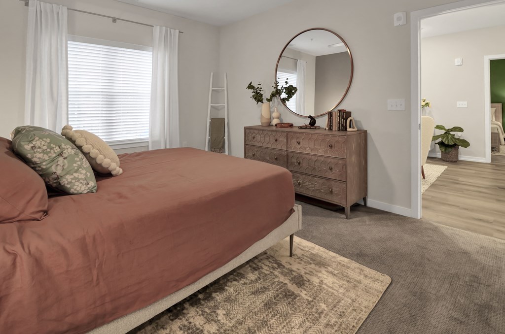 a bedroom with a bed and a dresser with a mirror