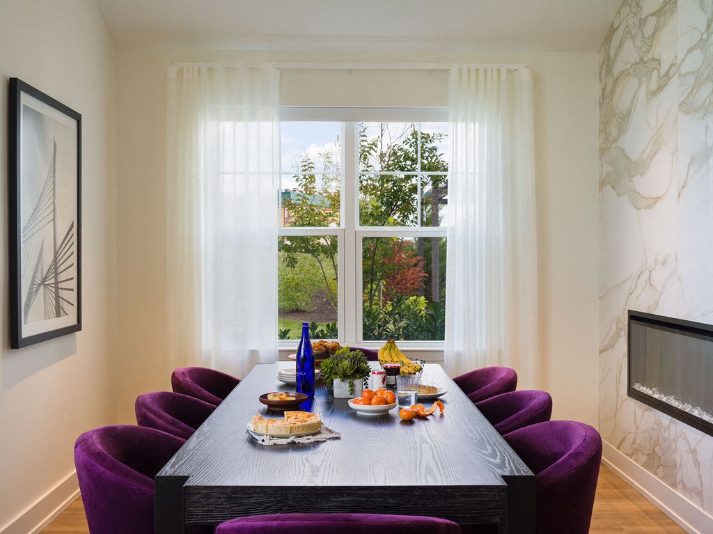 a dining room with a large window and a table with food on it