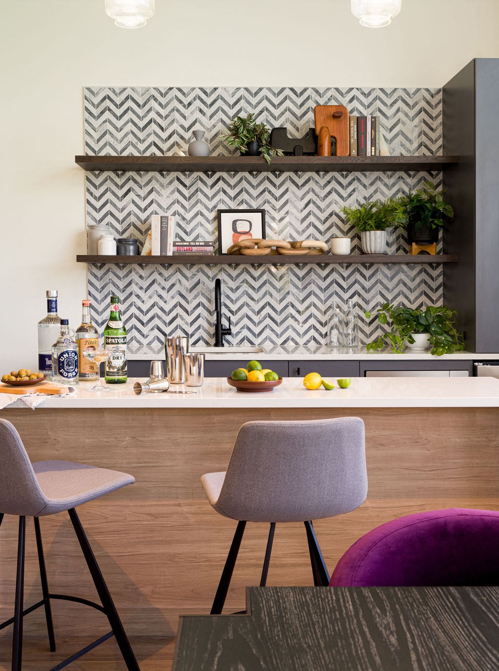a kitchen with a counter and chairs and shelves
