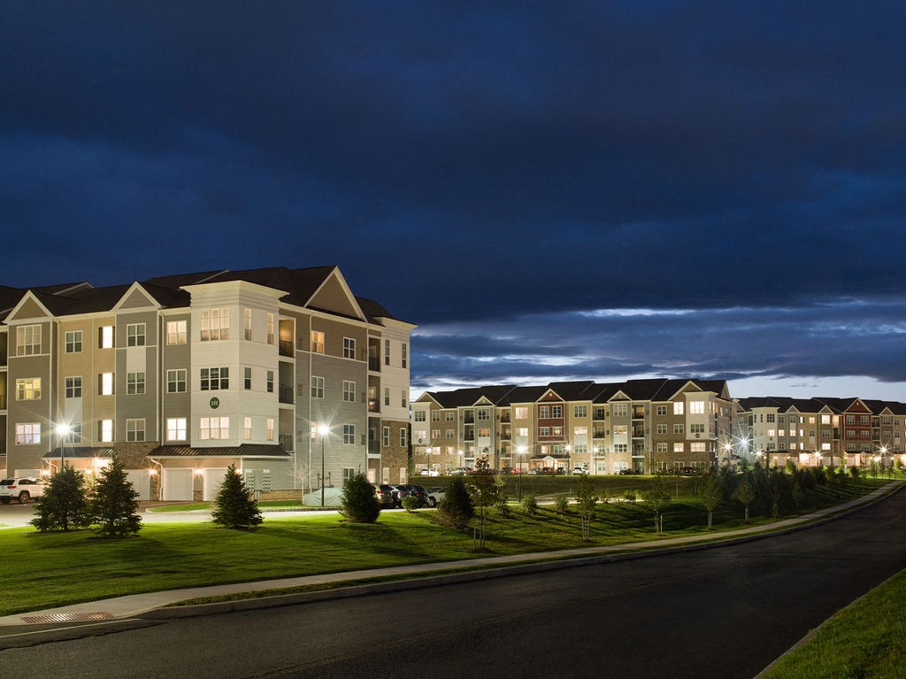 an exterior view of an apartment building at night