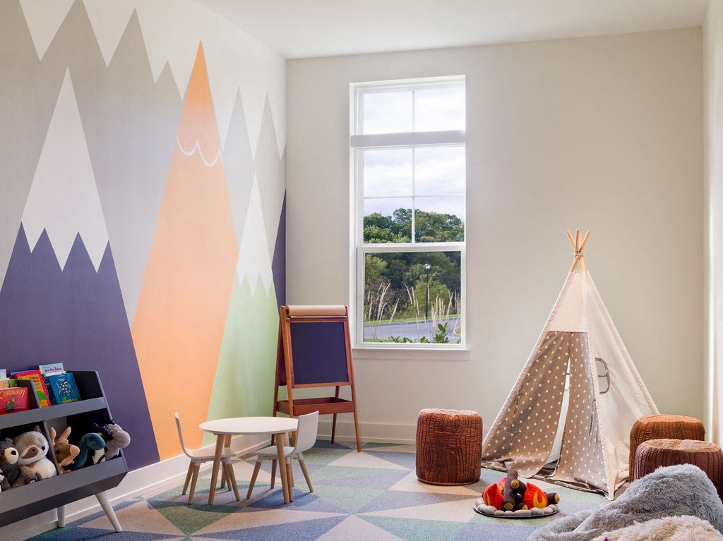 a childrens room with a tent and mountains on the wall