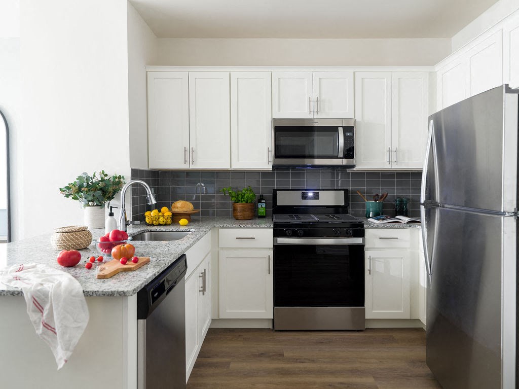 a kitchen with stainless steel appliances and white cabinets