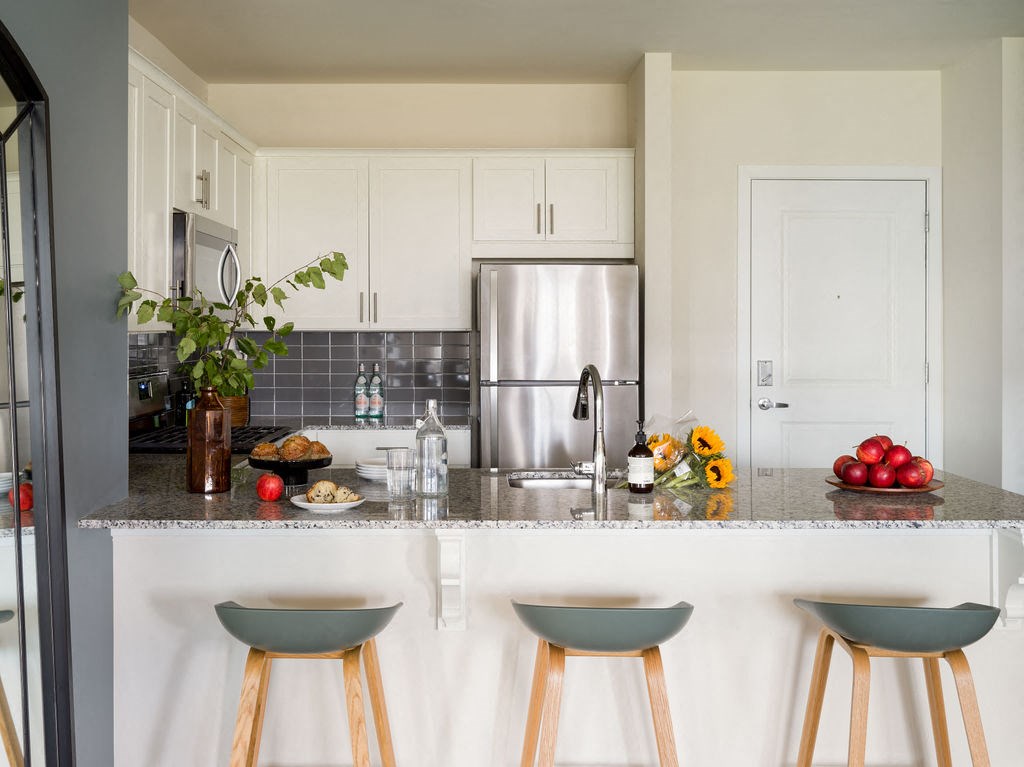 a kitchen with a granite counter top and a stainless steel refrigerator