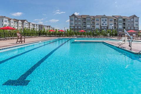 A large swimming pool in front of apartment buildings.