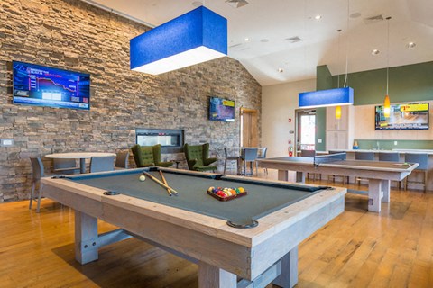 A pool table with a green cloth and a billiard cue on it.