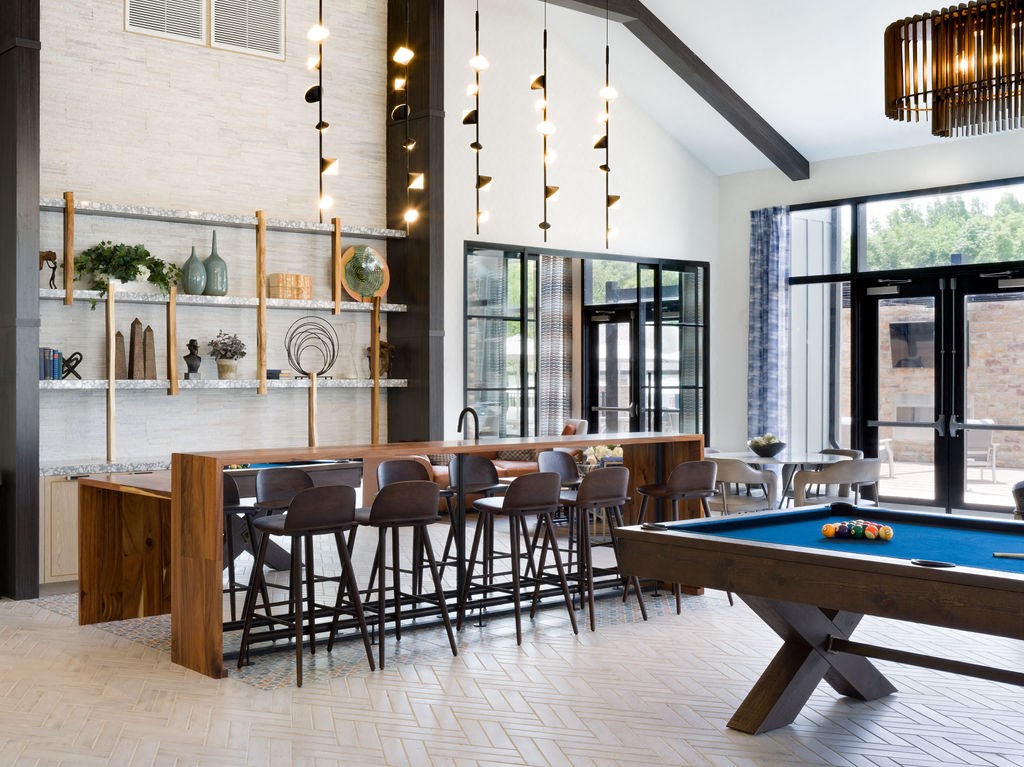a pool table and a bar in a room with glass doors