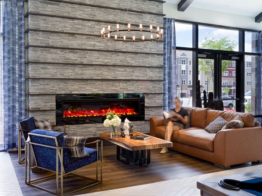 a man sitting on a couch in a living room with a fireplace