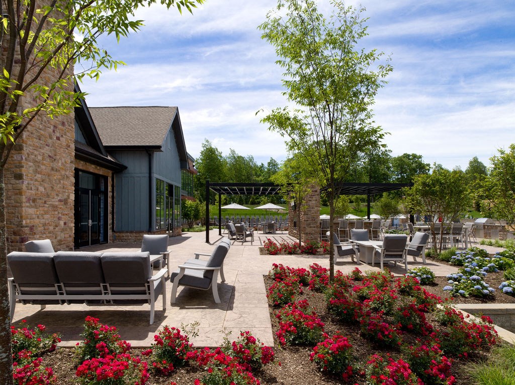 a patio with chairs and tables in front of a building