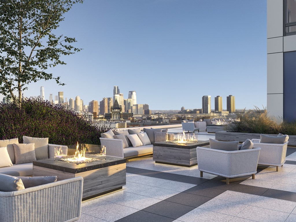 a terrace with couches and tables overlooking a city skyline