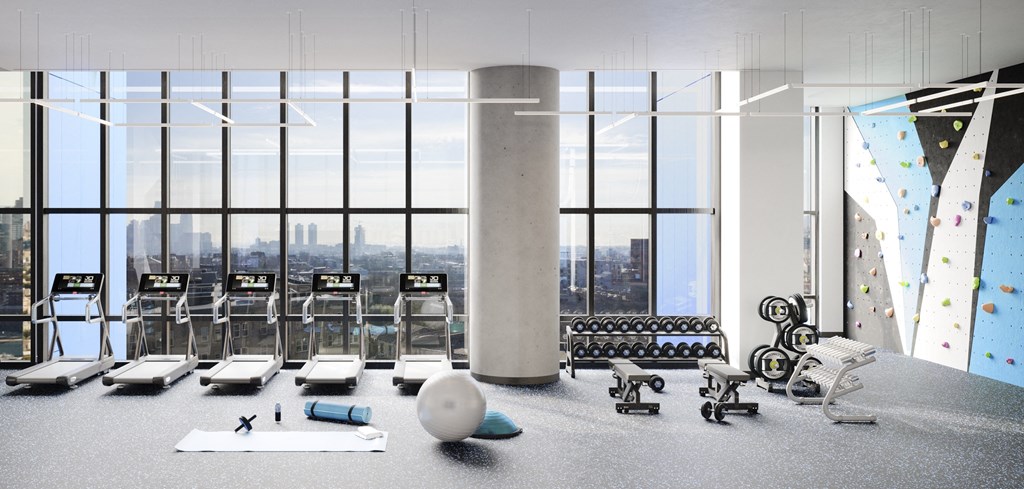 a gym with floor to ceiling windows and weights and yoga machines