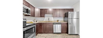 A kitchen with brown cabinets and stainless steel appliances.