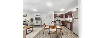 A kitchen with a dining table and chairs in the middle.