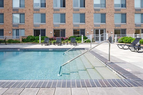 a swimming pool in front of a brick building
