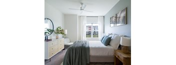 a bedroom with a bed and a large window
