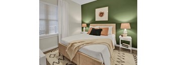 A bedroom with a bed, nightstand, and lamp.