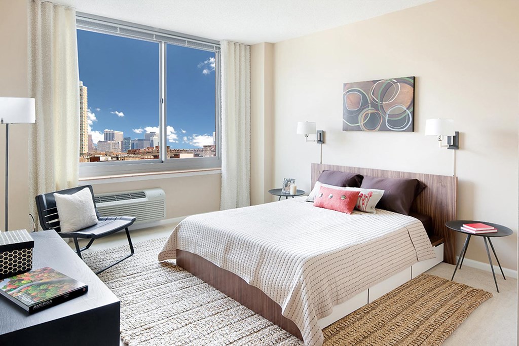 a bedroom with a bed and a large window