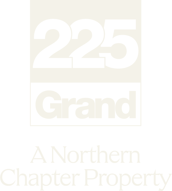 A green sign with the number 225 and the word Grand on it.