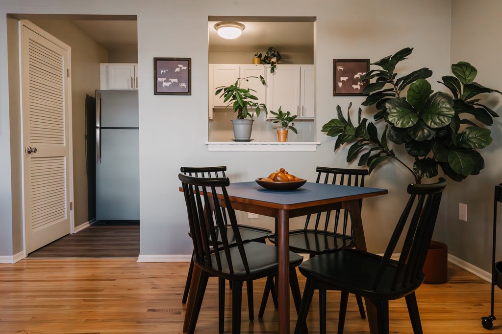 a dining room with a table and chairs and a refrigerator