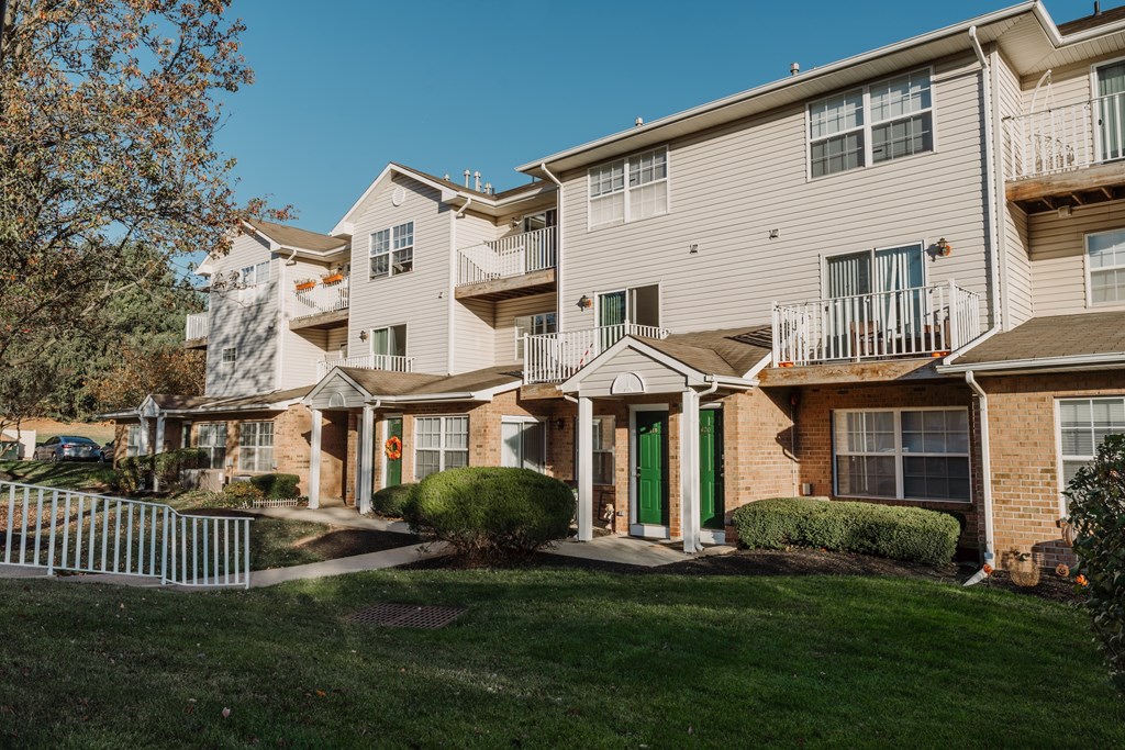 an apartment building with a yard and green grass