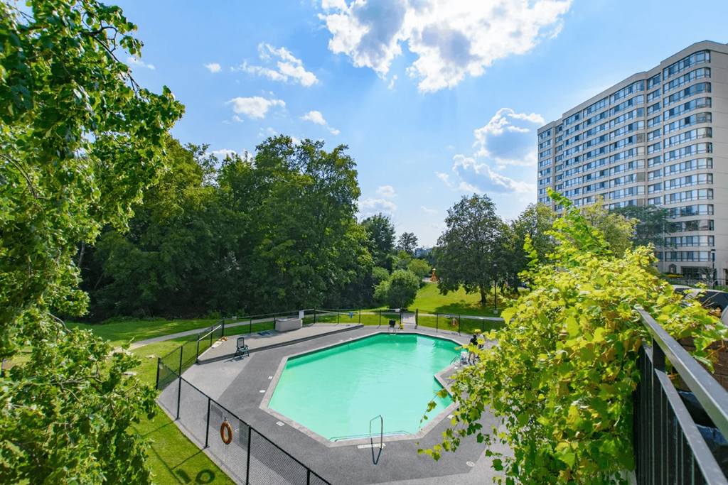 A swimming pool surrounded by a fence and trees.