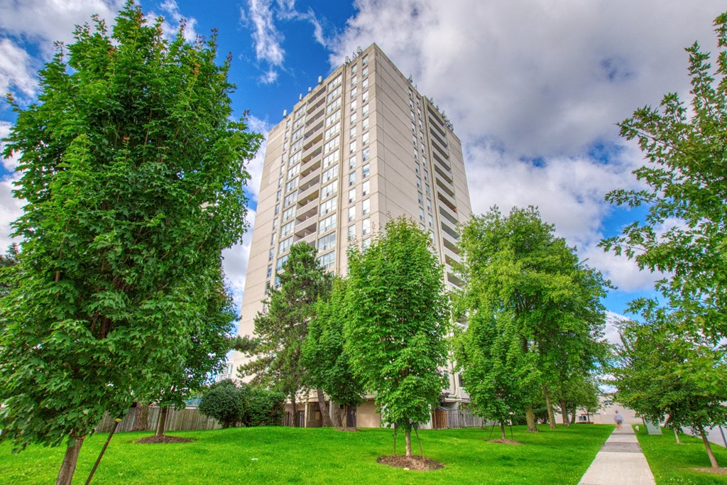 an image of an apartment building in a park with trees