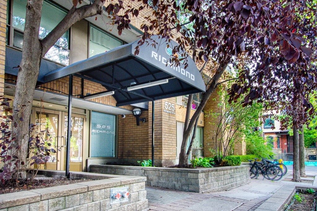 a building with a tree and a sidewalk in front of it