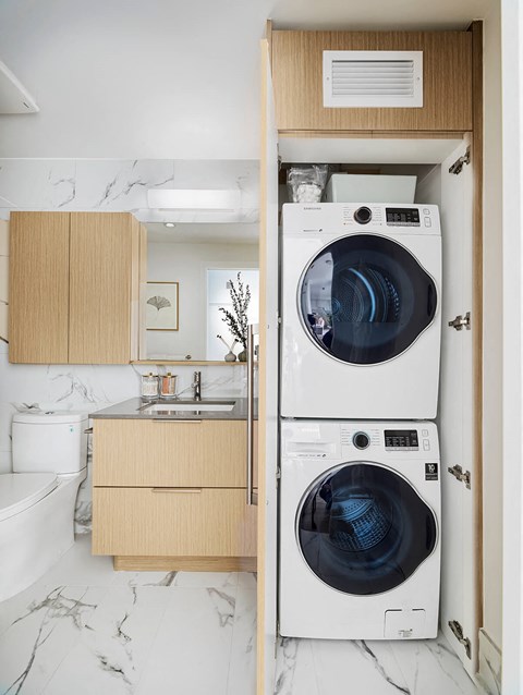 A washing machine is in a cabinet in a kitchen.