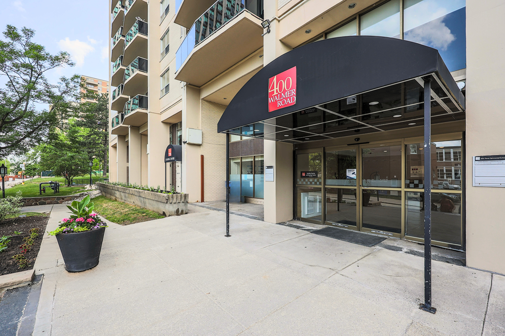 a building with a black awning and a large potted plant in front of it