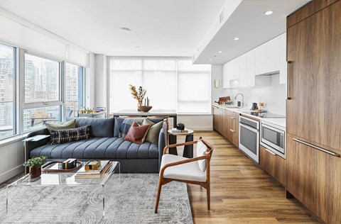 A modern living room with a grey sofa and a wooden chair.
